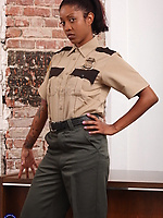 Tattooed nude woman posing in boots after uniform stripping