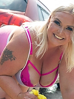 Mature milf curvy babe in pink lingerie teases big booty at outdoor car wash