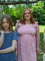 Clothed milfs in floral dresses posing outdoors in a casual picnic scene