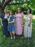 Clothed milfs in floral dresses posing outdoors in a casual picnic scene