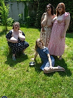 Clothed milfs in floral dresses posing outdoors in a casual picnic scene