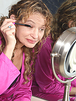 Mature babe in pink getting naked by the mirror with juicy tits out