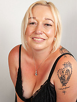 Blonde mature strips black lingerie and rides dildo on bed