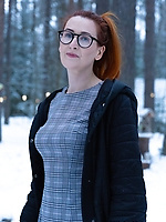 Redhead with glasses flashing outdoors