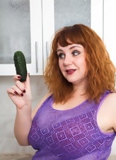 Red-haired BBW plays with pickle in her spacious kitchen