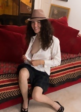 Smiling brunette in hat spreads legs showing very hairy cunt
