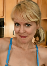 Blonde MILF with shaved pussy strips in kitchen porn photos