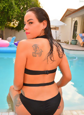 Black-haired MILF shows perky tits while relaxing in the pool
