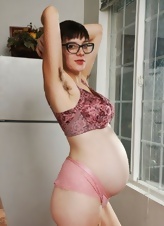 Pregnant MILF with short hair shows her bush in solo pictures