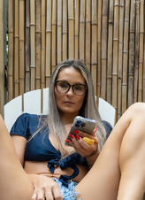 Glasses-wearing hottie is ready to massage her twat for the camera