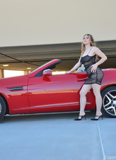 Blonde MILF is posing next to a car and masturbates right after