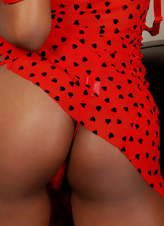 Ebony woman in a sexy red dress plays with her wet pussy